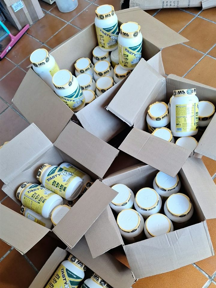 Caixas com potes de Tasty Whey